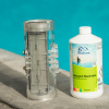 Bouteille de nettoyant électrodes Chemoform posée au bord d’une piscine, à côté d’une cellule d’électrolyseur propre et transparente