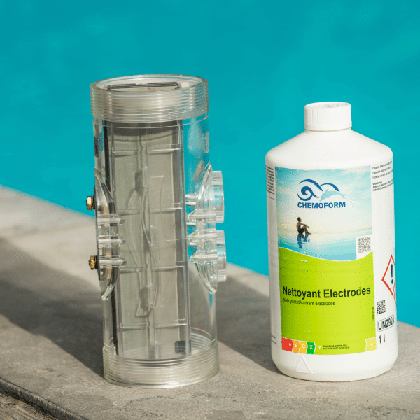 Bouteille de nettoyant électrodes Chemoform posée au bord d’une piscine, à côté d’une cellule d’électrolyseur propre et transparente