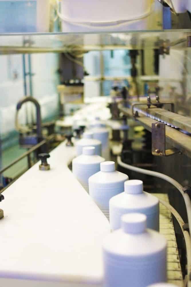 Ligne de production automatisée Chemoform en Allemagne avec des flacons de produits piscine avançant sur un convoyeur.